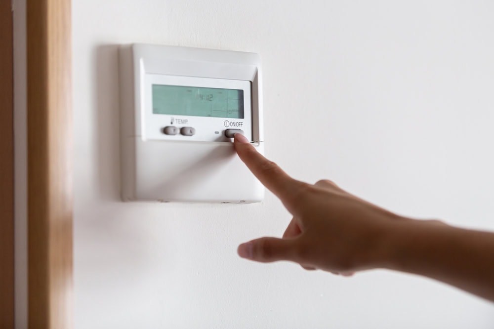 setting heat thermostat to correct temperature when going away for winter vacation to keep home comfortable and protected