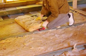 installing insulation on the floor of a two-story home to improve the efficiency and comfort