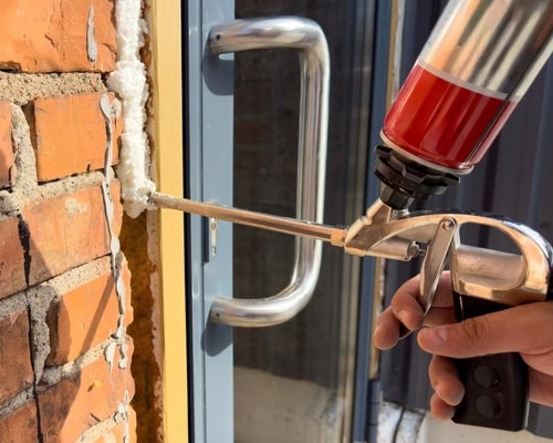professional using caulk and foam for air sealing home and improving the insulation and air quality for those living inside