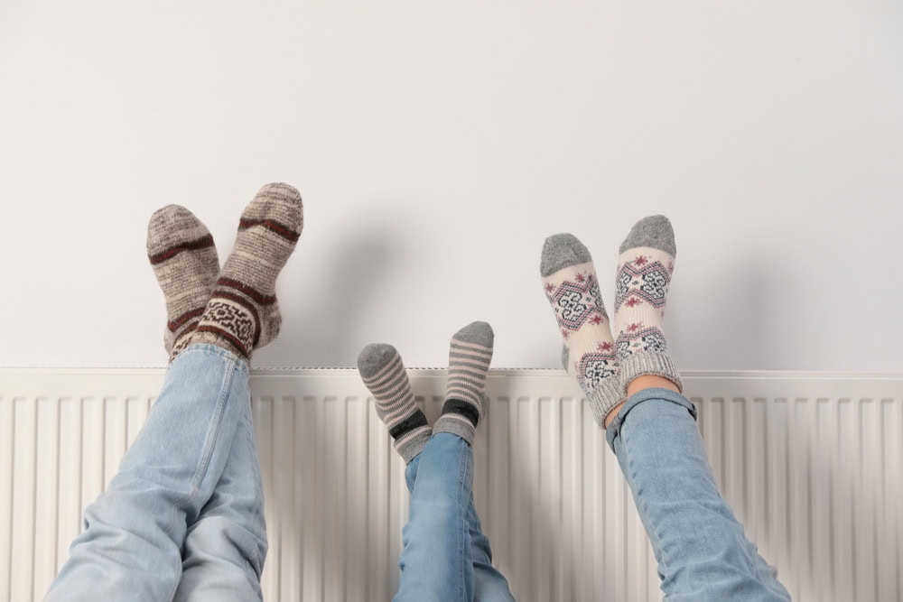 family keeping warm in the winter by using heating system and insulation and avoiding increasing utility bills