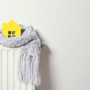 House,Model,Wrapped,In,Scarf,On,Radiator,Indoors,,Space,For
