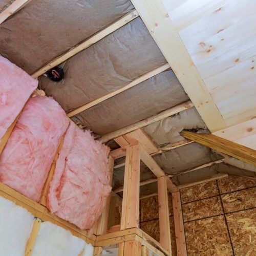 fiberglass insulation on ceiling of home being built renovated for better home comfort and improved ventilation and lower utility bills compared to blown in cellulose